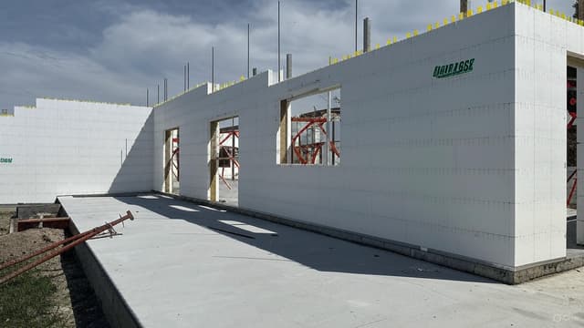 A construction team assembling insulated concrete forms for a building wall.