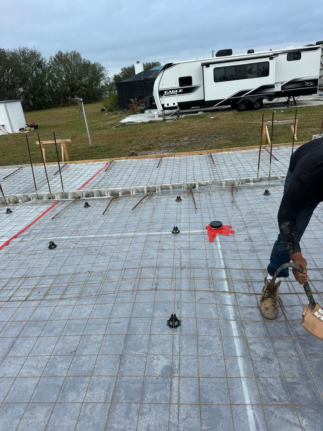 Workers constructing a wooden roof frame on a building site.